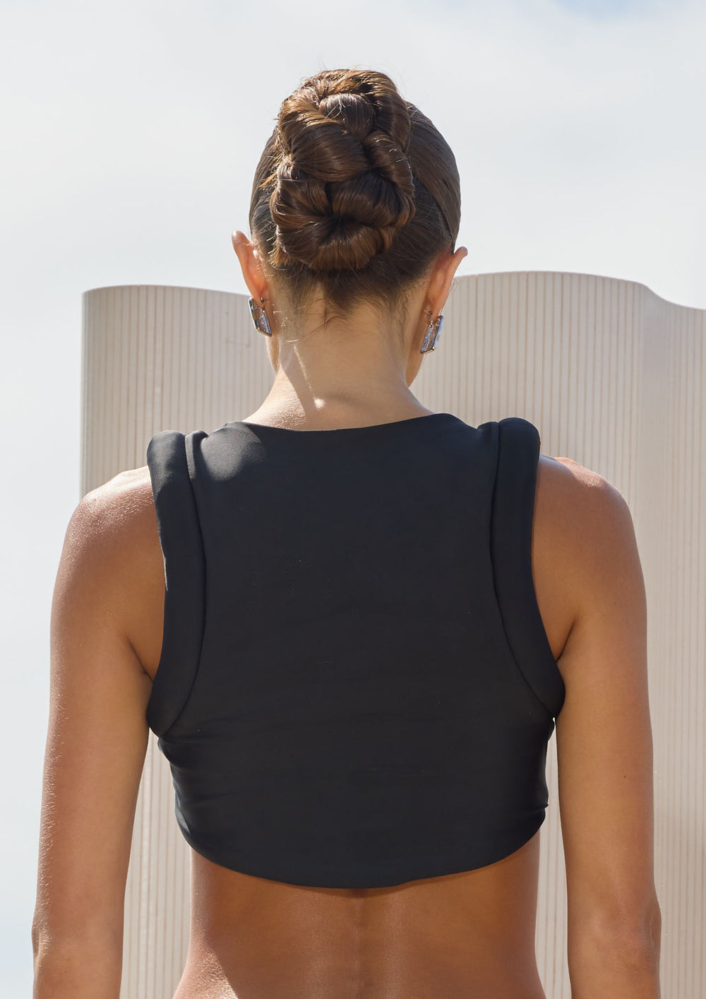 Person wearing a black bikini top with a blurred background