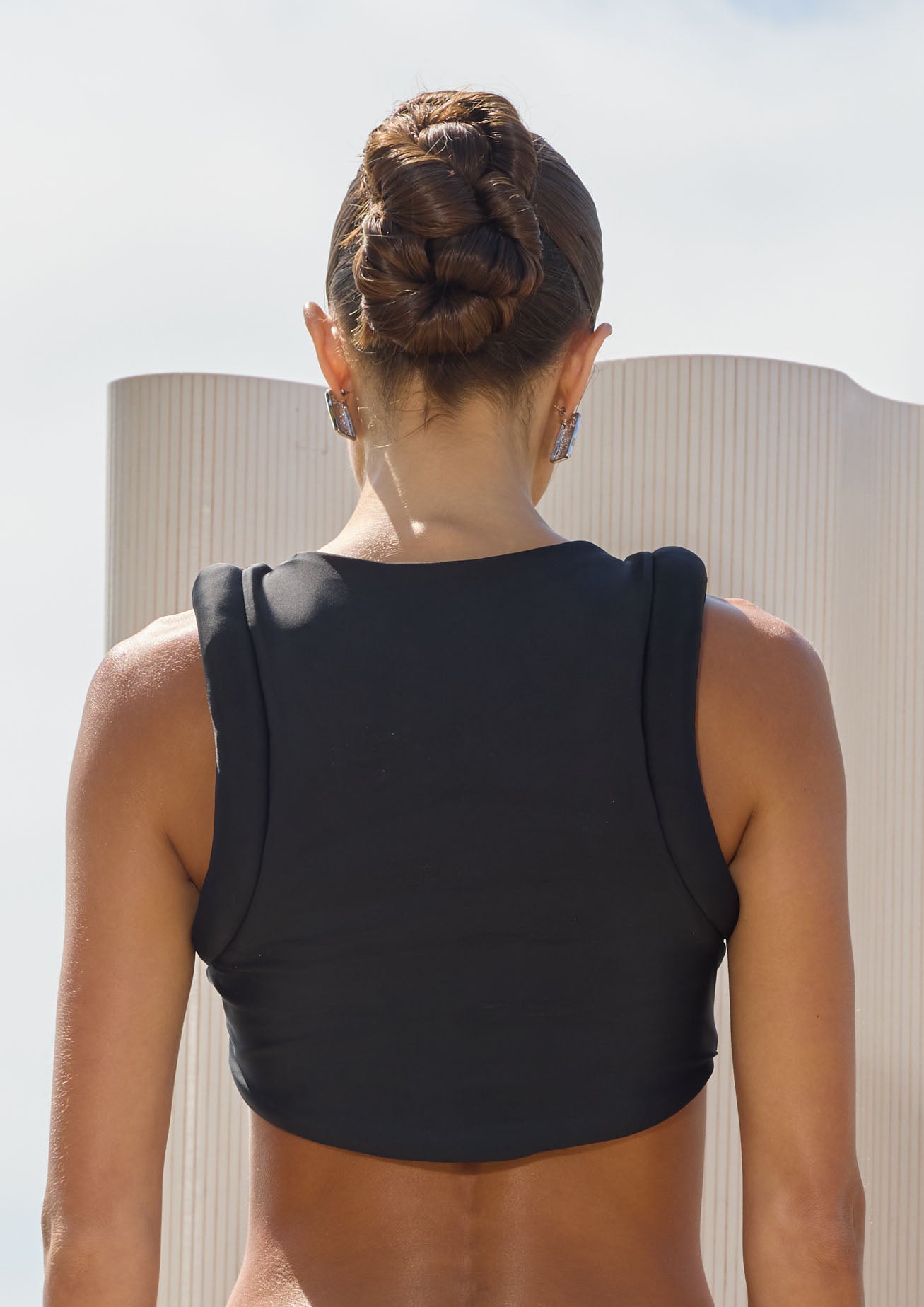Person wearing a black bikini top with a blurred background